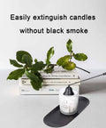 Long Reach Candle Snuffer Extinguisher Tool with Swivel Bell for Deep Jar Candles in use on a white candle, greenery in background.