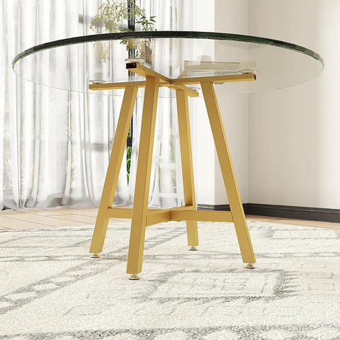 Gold X Shape Table Base For Glass Wood Marble Tops with round glass top, 28-inch height, modern design in bright room.