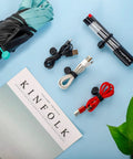 Cord Organizer And Cable Ties Set With Super Handy Magnetic Clips holding pens, cables, and umbrella, 12 Pack Black displayed.