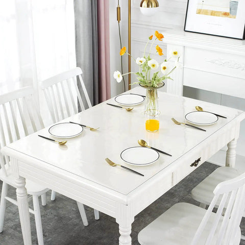 Clear Desk Protector 1.5mm Thick 14 By 24 Inches Heavy Duty Vinyl Desk Pad on a white dining table set with plates and cutlery.