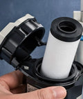 Hand holding AF40P-060S Replacement Air Filter Element for AF40 Series, visible in open filter housing, 5 micron nonwoven filtration.