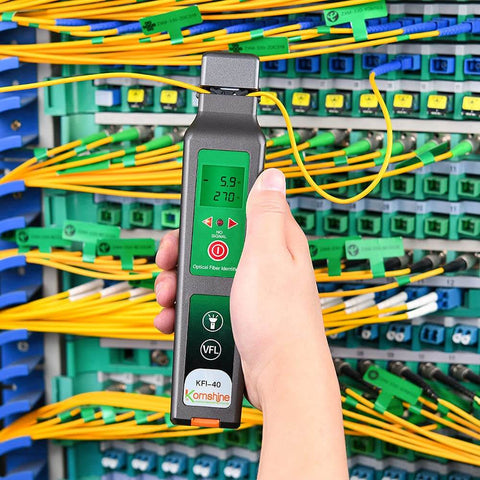 Technician using KFI-40 Fiber Optic Detector And Live Identifier For 0.25mm, 0.9mm, 2.0mm And 3.0mm Cables at a fiber distribution panel
