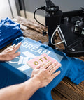 Person using Cooling Block For DTF Transfers Fast Cold Peel Printing Tool on a blue shirt with heat press machine.