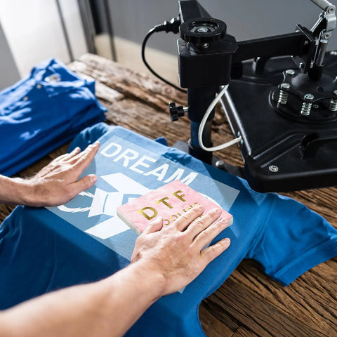 Person using Cooling Block For DTF Transfers Fast Cold Peel Printing Tool on a blue shirt with heat press machine.