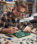 Man using 60W LED Display Soldering Iron Kit With Ceramic Heater, Adjustable Temperature Soldering Gun, 12 In 1, on circuit board