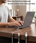 Man using desk with Six Pack Black Cord Organizer Clips For Cables And Chargers neatly securing cables on wooden surface