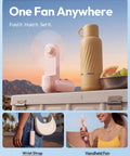 3 In 1 Portable Handheld Fan Foldable Lipstick Size USB Rechargeable Personal Cooler in pink, shown with a bottle and fruit on a table.