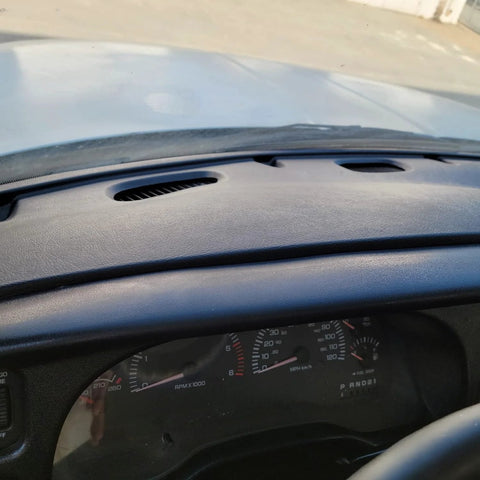 Installed ECOTRIC dash bezel cover for Dodge Ram, black plastic with vent slots above instrument cluster.