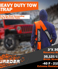 Person holding Heavy Duty Tow Strap 3 Inch By 30 Foot Snatch Recovery Rope for off-road towing with red vehicle in background.