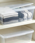 Heavy Duty Clear Plastic Storage Bins Are The Real Deal With Secure Snap Top Lid Stackable Under Bed Totes 28 Quart holding rolled clothes and socks on shelf.