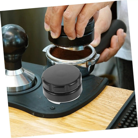 Pro Grade Reusable Metal Tamper Set for Espresso Machines in use, showing hand pressing espresso grounds on a wooden coffee bar.