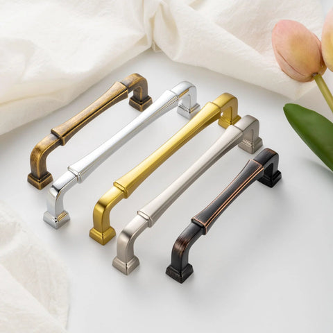 Variety of metal cabinet pulls with different finishes on display, including oil rubbed bronze. Kitchen and drawer hardware collection.