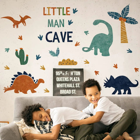 Peel And Stick Dino Footprints Wall Decals For Nursery And Playroom Baby Room Art Watercolor Blue Coconut Trees Cactus Jungle Theme Decor For Kids Room Gift on wall above kids on couch.