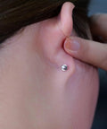 Solid Implant Grade Titanium Screw Back Earrings Made For Sensitive Skin With Hypoallergenic F136 Studs That Stay Put And Keep Your Jewelry Low Drama Always, worn in ear with a white opal stone.