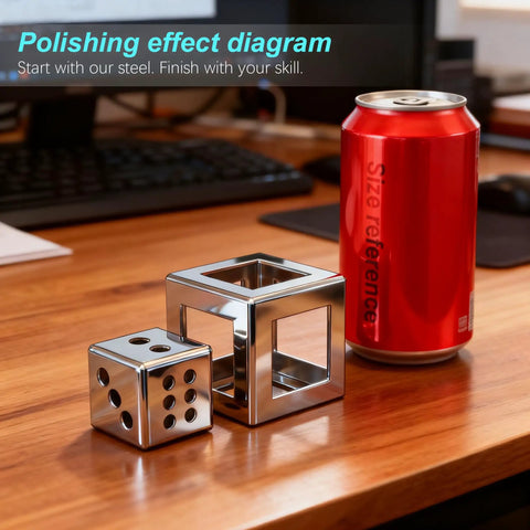 Dice-shaped and cube-shaped polished steel objects with a red can for size reference on a wooden desk.