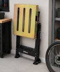 Heavy Duty Welding Table 36x18 Inch Portable Workbench On Wheels With Braking Lockable Casters shown folded against wall