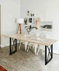Industrial Triangle Table Legs 28 Inch Set Of 2 Cast Iron Welded Black Desks Nightstands Coffee Tables Diy Ready With Four Adjustable Pads Heavy Duty Wrought Iron Legs For Modern Farmhouse And Industrial Furniture supporting a wooden tabletop in a modern dining setting.