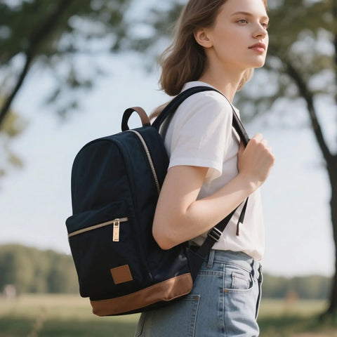 Person wearing a black backpack outdoors with gold zipper pull visible.