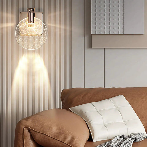 Crystal Bubble Wall Sconce LED Light In Nordic Gold Finish illuminating modern living room with glass bubble shade.