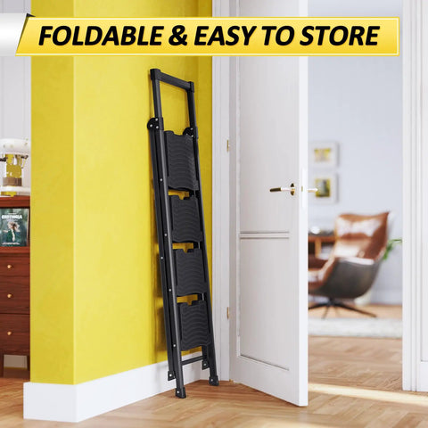 4 Step Folding Ladder With 900 Lbs Capacity, Anti Slip Wide Pedals And Handrails, folded and stored against a wall in a room