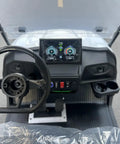 Interior view of White Eight Passenger Electric Golf Cart Rolled Up Tight With Beefy Dual Arm Suspensions Silky Smooth Five Kilowatt Motor Plus Touchscreen Audio And Deep Reclining Lounge Seats showing steering wheel and dashboard.