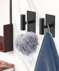 Self Adhesive Aluminum Hooks Heavy Duty Wall Mount Hangers No Drill Stick On For Towel Coat Robe Shower Bedroom Bathroom Kitchen Black 6 Pack Rust Resistant holding bath items against tile wall.