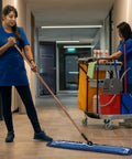 Two women cleaning an indoor space with a 24 Inch Heavy Duty Cotton Dust Mop Refill Washable Replacement Heads for Large Spaces and Warehouses.