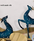 Two decorative elk figures made of metal with a snowy design, suitable for festive wall decor.