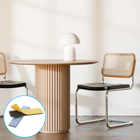 Eight Piece Premium High Density Self Adhesive PTFE Rectangle Furniture Glides under black chair on wood floor.