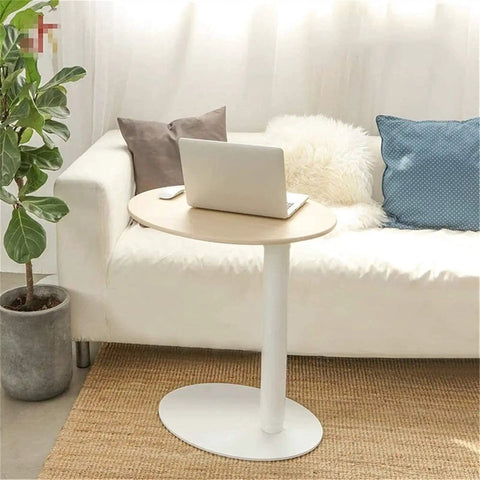 Adjustable Height Rolling Laptop Stand With Spacious Work Surface Smooth Caster Wheels Portable Computer Desk For Bedroom Living Room And Home Office Kick Back Ready Workstation next to a sofa with a laptop on top.