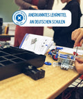 Hands assembling metal construction skid steer loader model kit 365 piece set with tools and illustrated manual in classroom.
