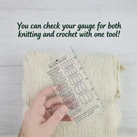 Hand holding Super Crisp Acrylic Gauge Ruler For Knitting And Crochet No Sweat Stitch Measurement Guide With Transparent Grid over textured knit fabric.