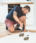 Person installing cabinets with 10 Pieces Double Acting Iron Door Hinges For Wine And Display Cabinets, retro style hardware visible