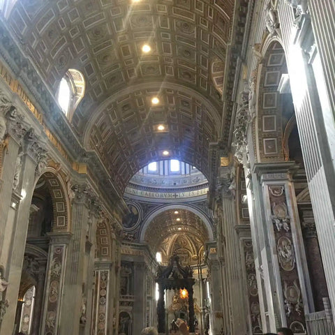 Interior of a grand cathedral with ornate arches and columns, showcasing intricate architecture and lit softly by natural light.