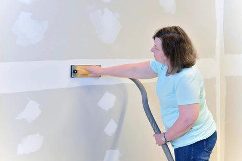 Person using Dust Free Drywall Vacuum Hand Sander With Six Foot Hose For Any Wet Dry Vacuum Easy Clamp Sanding Screen Replacement.