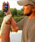 Man using Pocket Size Fishing And Luggage Scale With Built In Tape And Backlit LCD Display 110 Lb 50 Kg Digital Weighing Scale