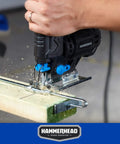 Hammerhead jig saw side view with blue knobs cutting wood on a workbench; dual blades visible.