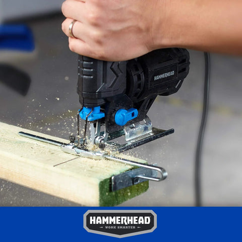 Hammerhead jig saw side view with blue knobs cutting wood on a workbench; dual blades visible.