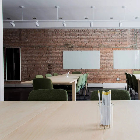 Modern office with brick wall, whiteboards, and tables under dimmable warm white MR16 LED spotlight bulbs, GU10 base.