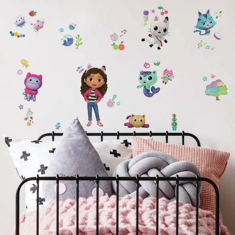 Gabby's Dollhouse Peel And Stick Wall Decals Set With 42 Pieces In Pink Purple Blue on white wall above child's bed.