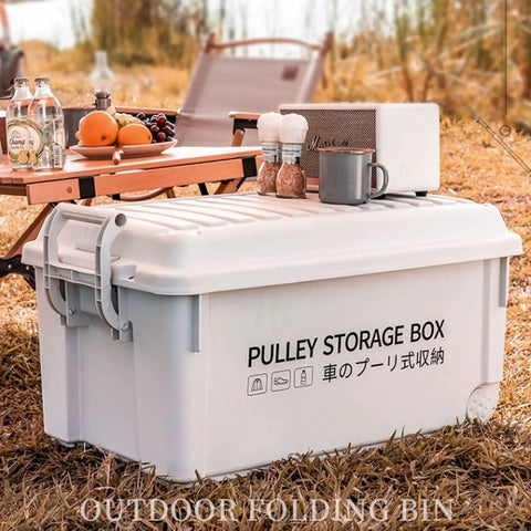 Heavy Duty Rolling Bin With Secure Lid And Easy Roll Casters, Stackable Outdoor Camp Organizer on grass by snacks and drinks.