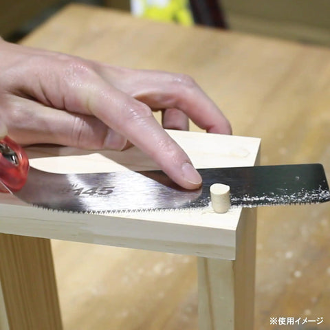 Using Top Tier Japanese Flush Cutting Hand Saw For Fine Woodworking on a wooden dowel for precise trimming.