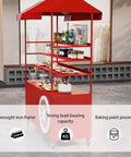 Kickass Rolling Cart With Red Striped Canopy And Wide Iron Top Heavy Duty Portable Vendor Stand On Smooth Casters With Lower Shelf For Street Food Sellers At Outdoor Festivals, featuring wrought iron frame and strong load-bearing capacity.