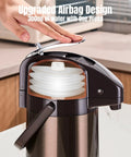 Hand pressing top of Upgraded Airpot Coffee Carafe With Double Pump Stainless Steel Drink Dispenser with Lazy Susan Base, showing airbag design