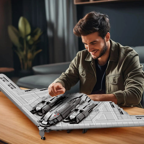 Man assembling Fighter Jet Building Set 33038 B2 Stealth Bomber Model Kit For Adults And Military Fans on a wooden table.