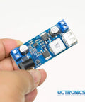 Hand holding Plug And Play Dual USB 5V Buck Converter from 9V to 36V input with stable 5V output up to 6A, showing USB port and components