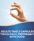 Hand holding a single capsule from Calcium And Magnesium Mineral Complex For Strong Bones And Muscle Support, 750 Mg Per Three Capsule Serving.