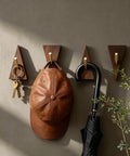 Solid Black Walnut Triangle Wall Hooks With Brushed Brass Caps, Heavy Duty Entryway Coat Rack, Hella Sturdy Key Holder That Keeps Your Living Space Totally Sick And Super Organized, displaying a cap and keys.