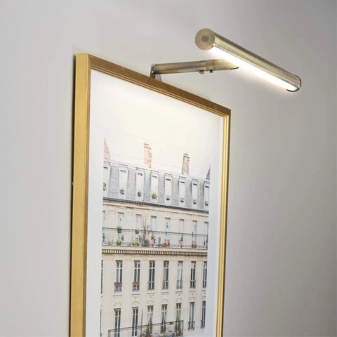 14 Inch Adjustable LED Picture Light In Antique Brass Dope Wall Art Lighting illuminating framed artwork with warm glow