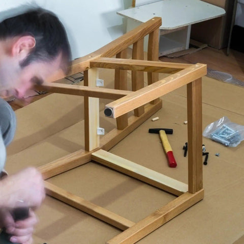 Man assembling furniture with Adjustable M10 Furniture Leveling Feet Set With ABS And Iron Inserts 30 Pack Heavy Duty Table Leg Levelers.